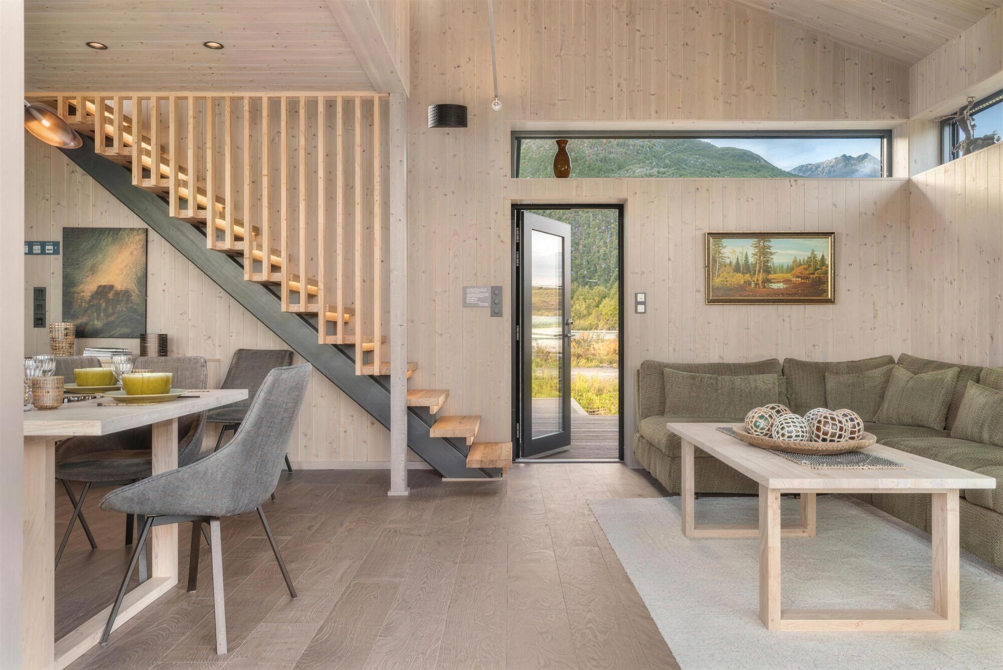 The living room in pale wood, with the stairs and a door open to the terrace